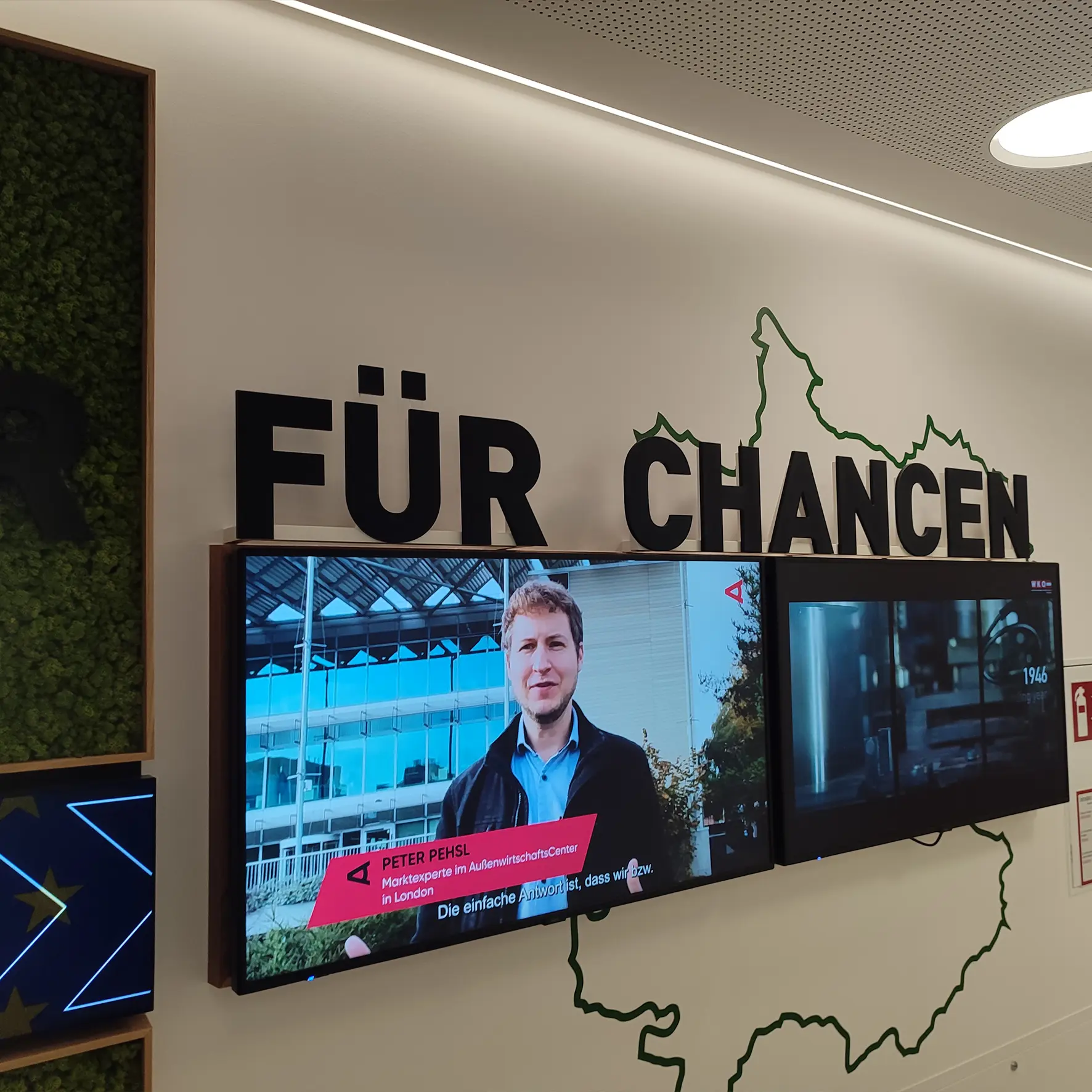 Acrylbeschriftung über einem Bildschirm als Wandgestaltung