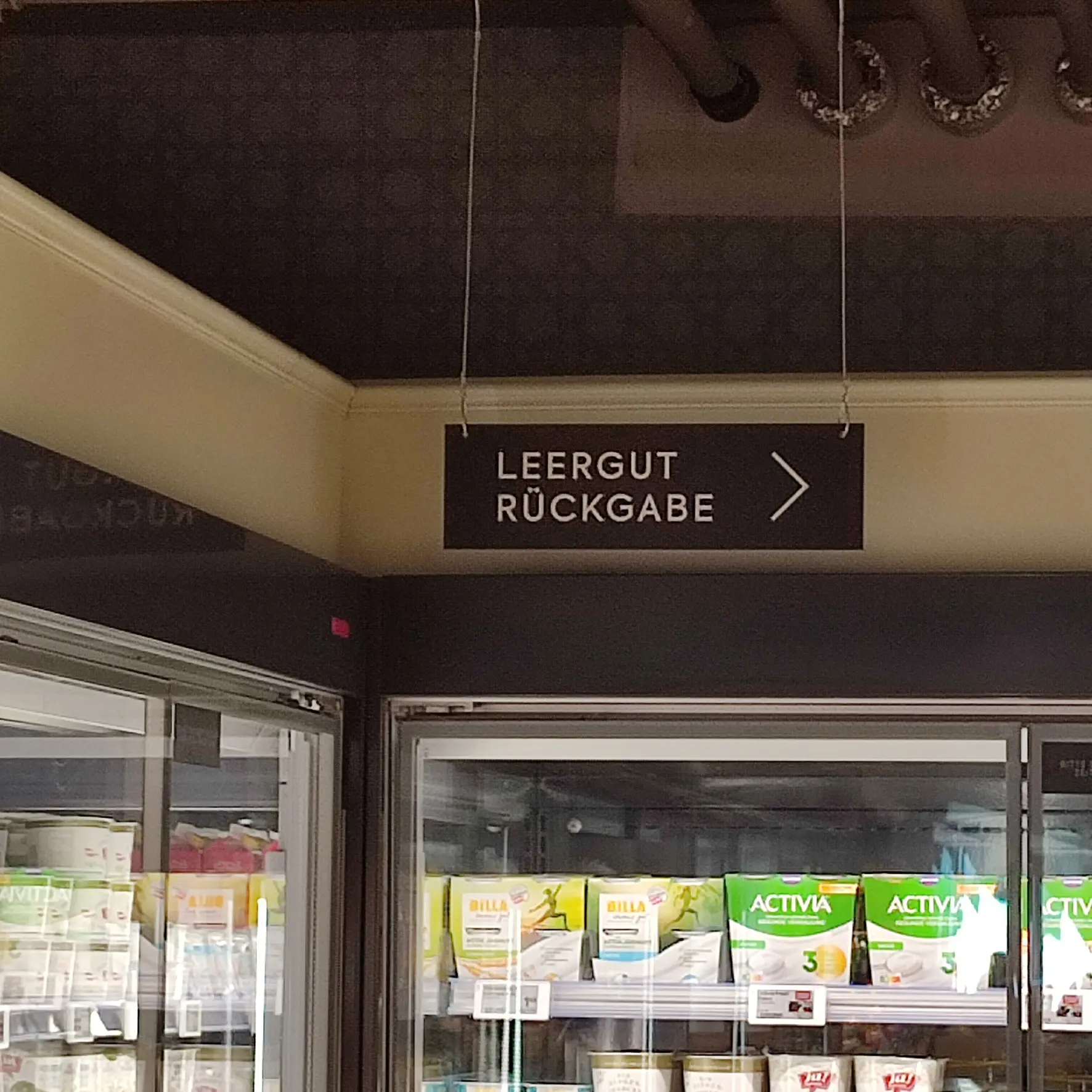 Plattendruck als Wegweiser aus Aluverbund von der Decke abgehängt