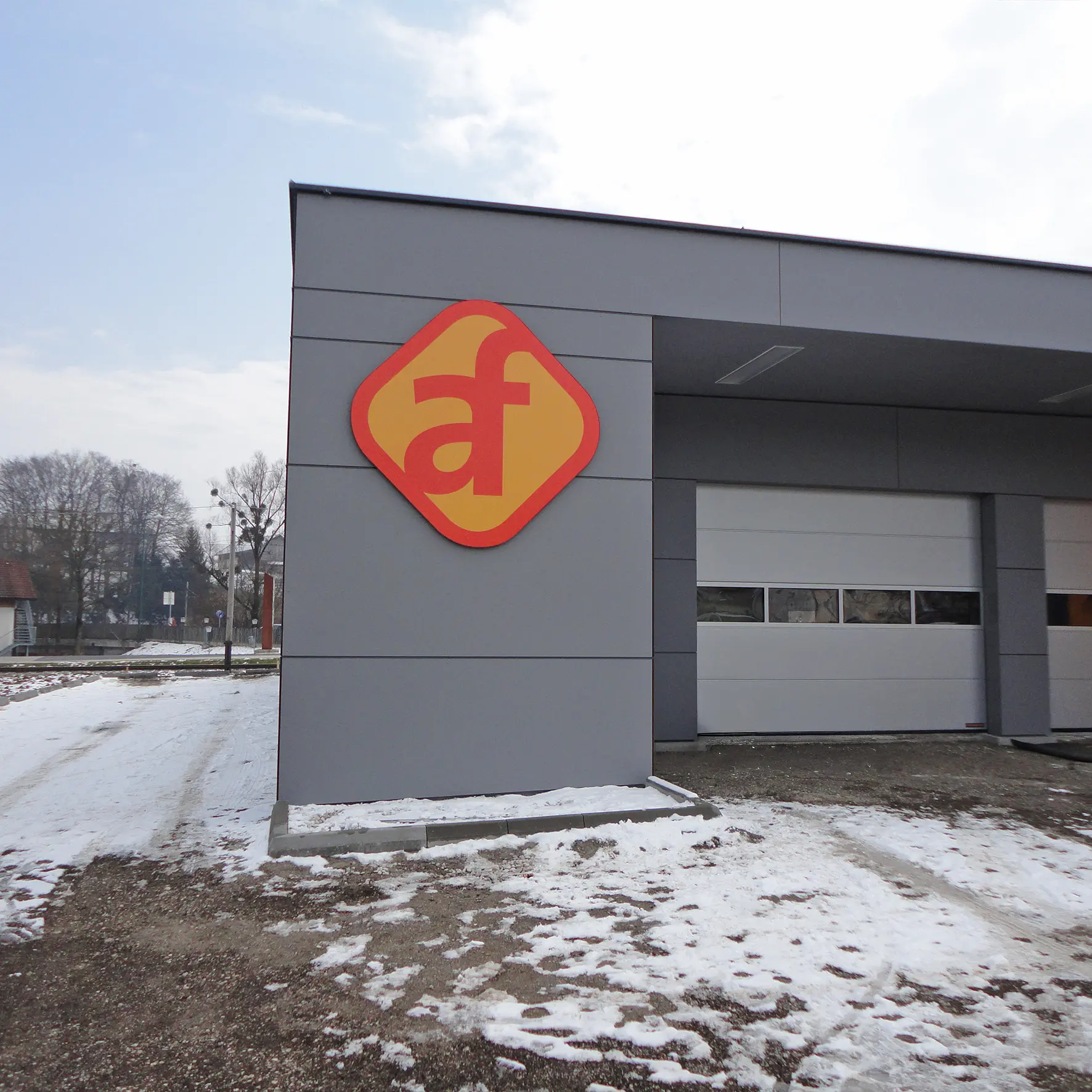 Firmenlogo in Kontur gefräst an Gebäudefassade