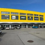 Fassadenbeschilderung mit Markenlogos an Gebäude Außenwand