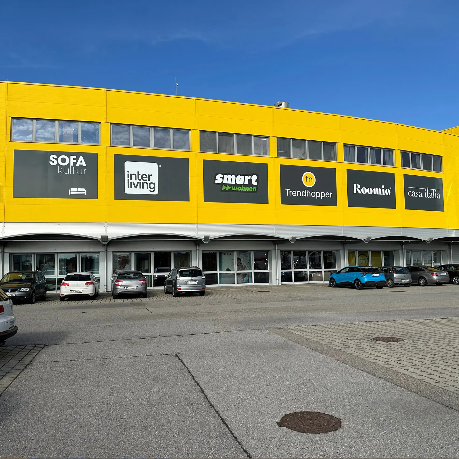 Fassadenbeschilderung mit Markenlogos an Gebäude Außenwand