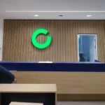 Frontleuchter im Innenraum – beleuchteter Schriftzug im Empfangsbereich eines Unternehmens