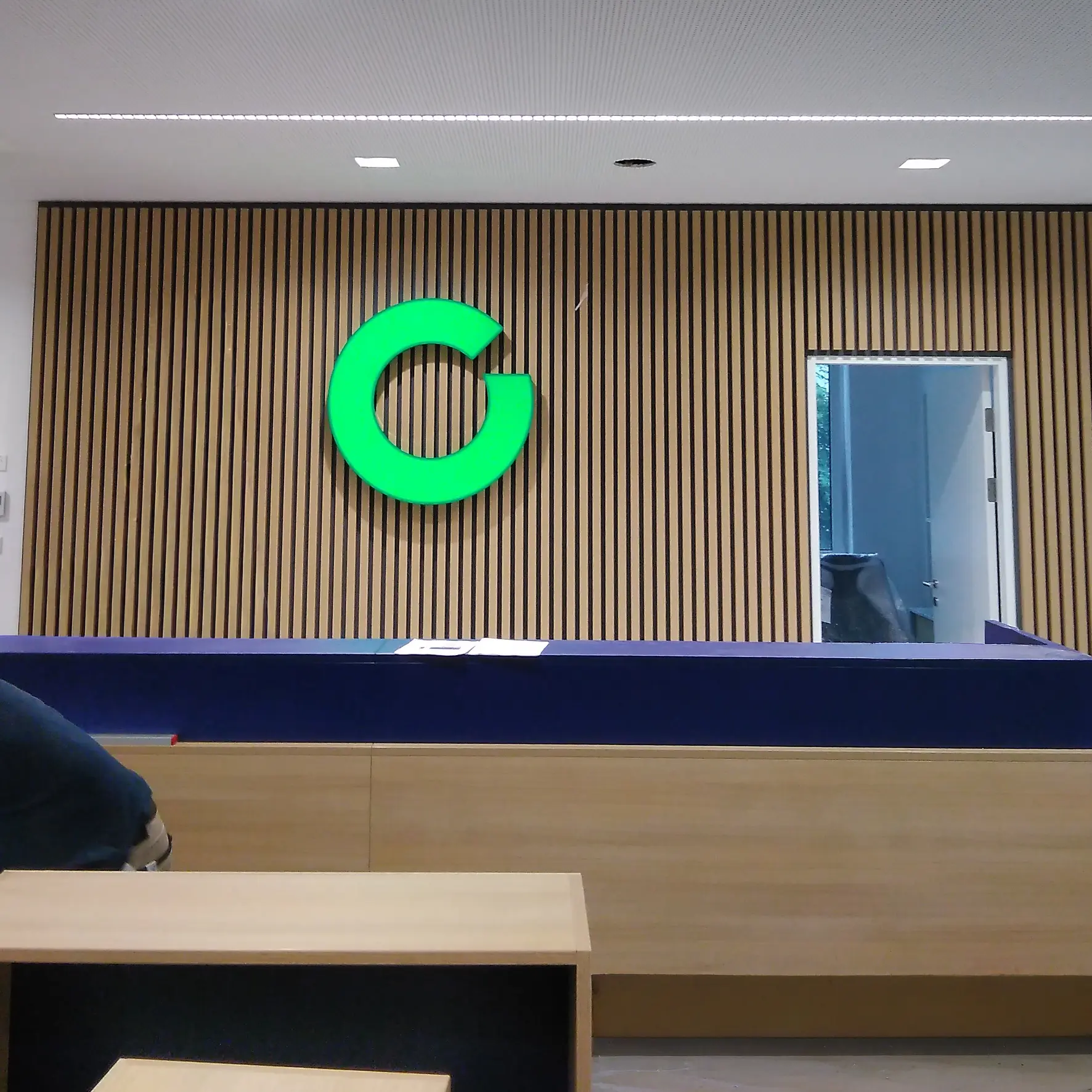 Frontleuchter im Innenraum – beleuchteter Schriftzug im Empfangsbereich eines Unternehmens