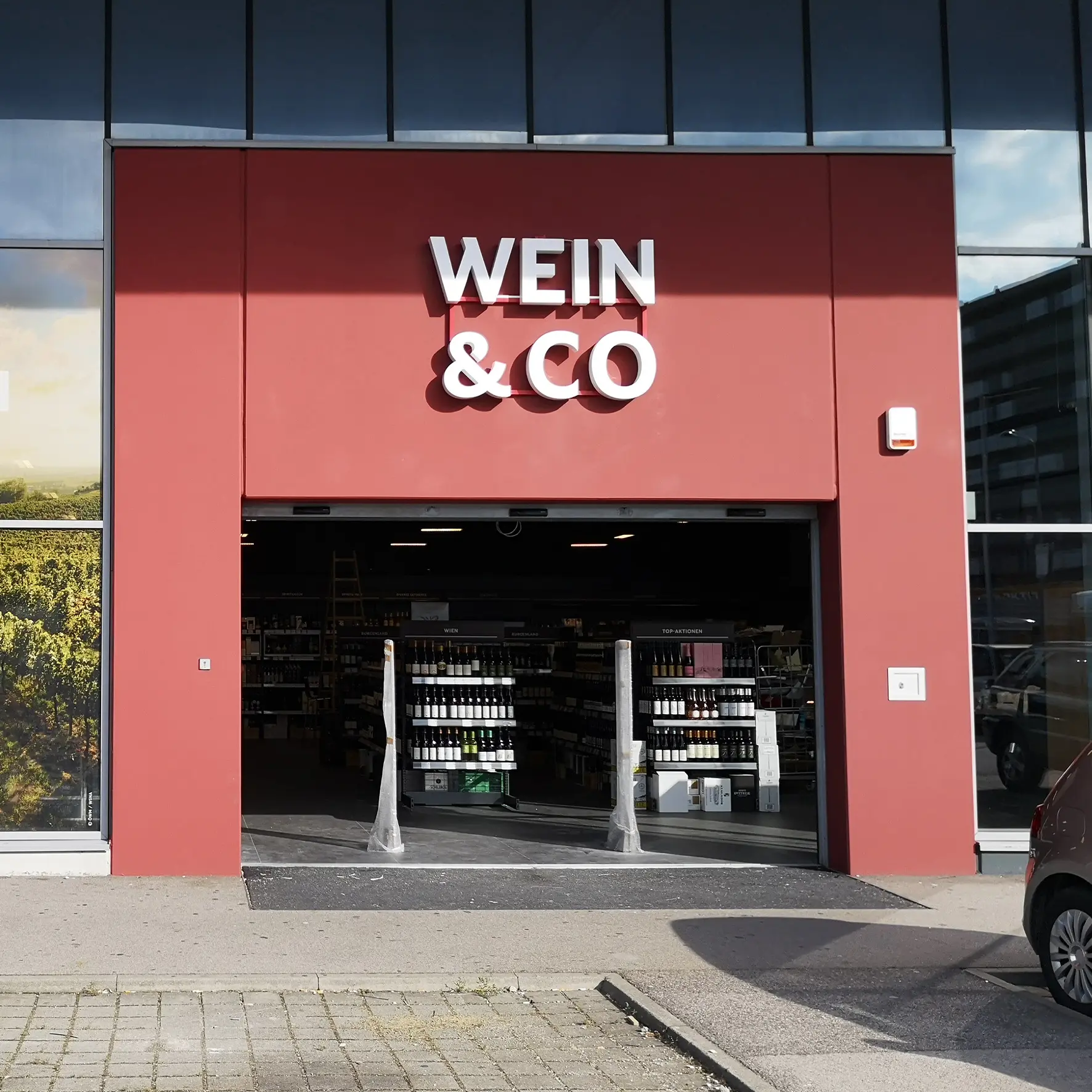 3D-Leuchtlogo aus Frontleuchtern über dem Eingangsbereich