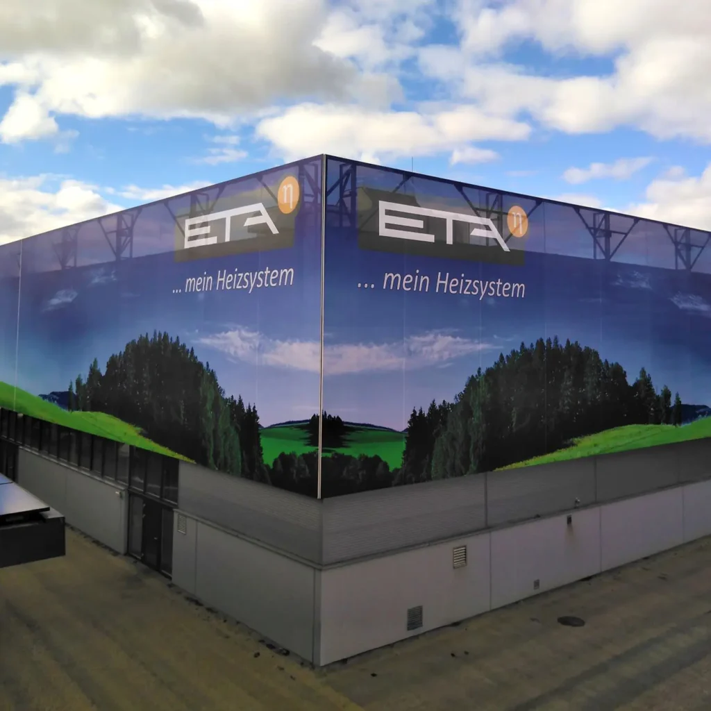 Durchscheinende Mesh-Fassadenbespannung mit bedrucktem Motiv an Gebäude