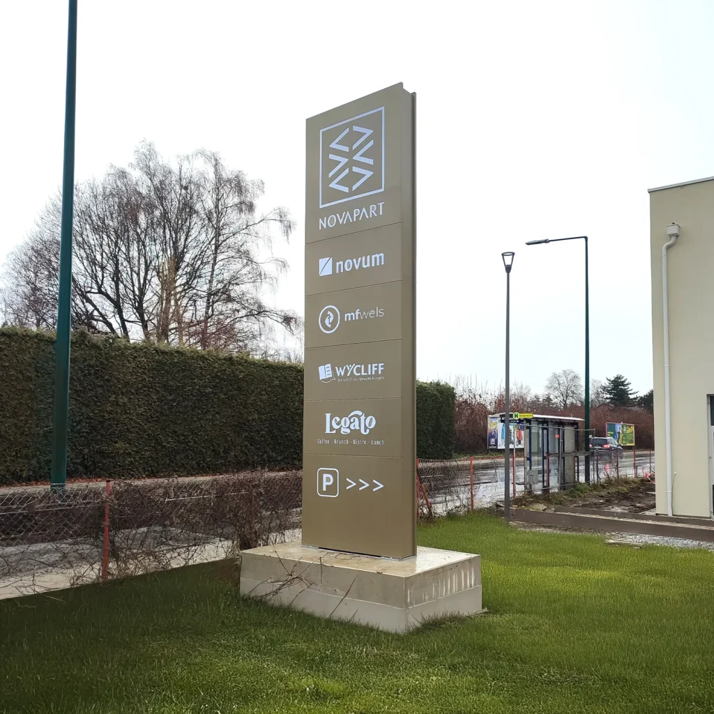 LED-Werbepylon mit Kassettenfront und ausgelasertem Acryllogos vor Firmengebäude