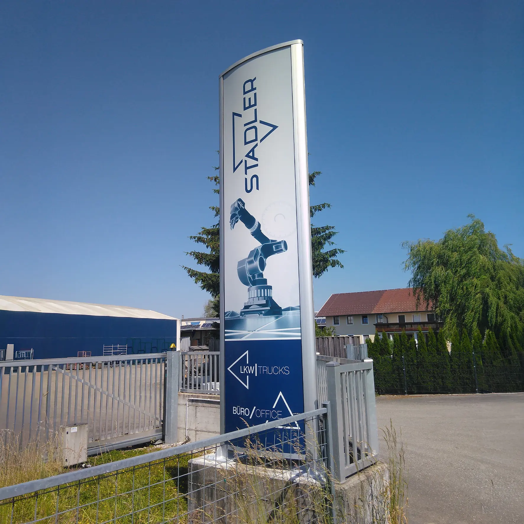 Frontansicht eines Werbepylons mit gebogener Acrylglasfläche