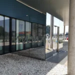 Glasfassade mit Sonnenschutzfolie für UV- und Hitzeschutz kombiniert mit Firmenlogo