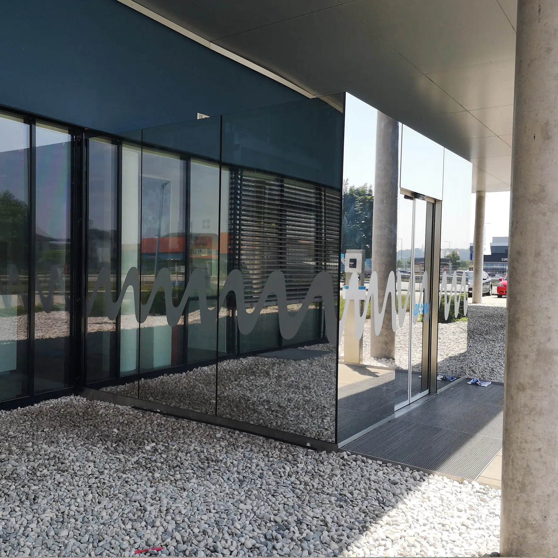 Glasfassade mit Sonnenschutzfolie für UV- und Hitzeschutz kombiniert mit Firmenlogo