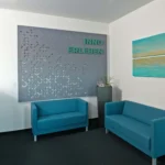 Individuell gestaltete EchoBoard Akustikwand mit Ausschnitten und farbigen Elementen