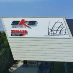 Werbetafel mit aufgesetzten Fräsbuchstaben an einer Firmenfassade