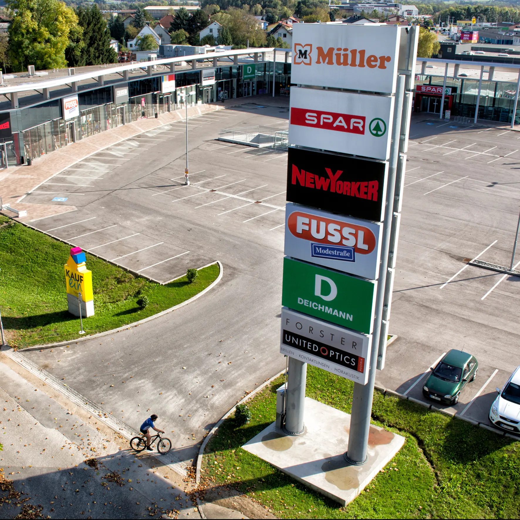 Außenwerbung: Werbeturm mit Acrylfront vor Einkaufszentrum