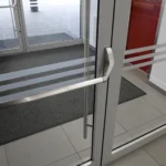 Nahaufnahme einer Anlaufschutzfolie auf Glastür gegen Fingerabdrücke und Stöße