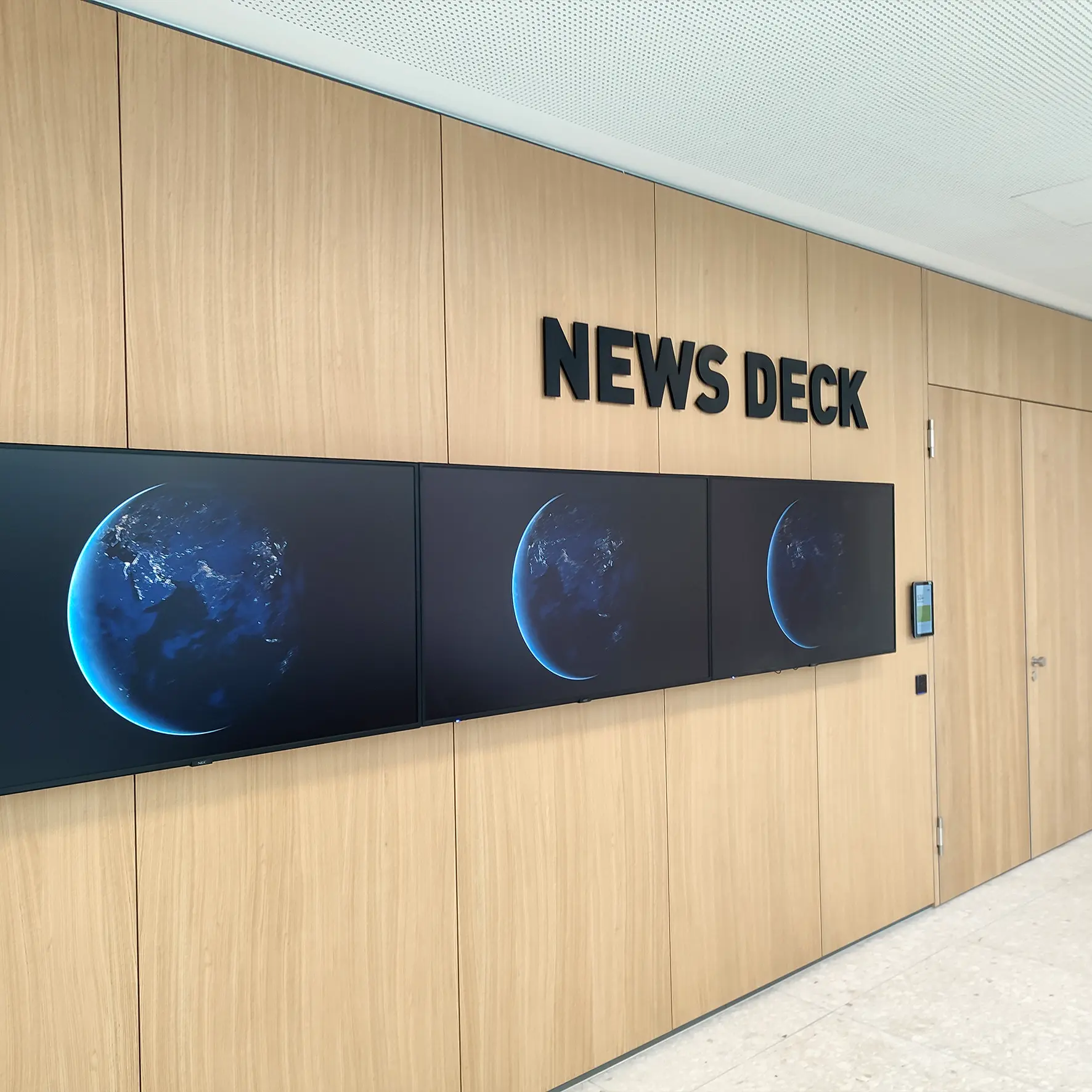 Acrylbuchstaben als eleganter Schriftzug im Eingangsbereich in Kombination mit Digital Signage