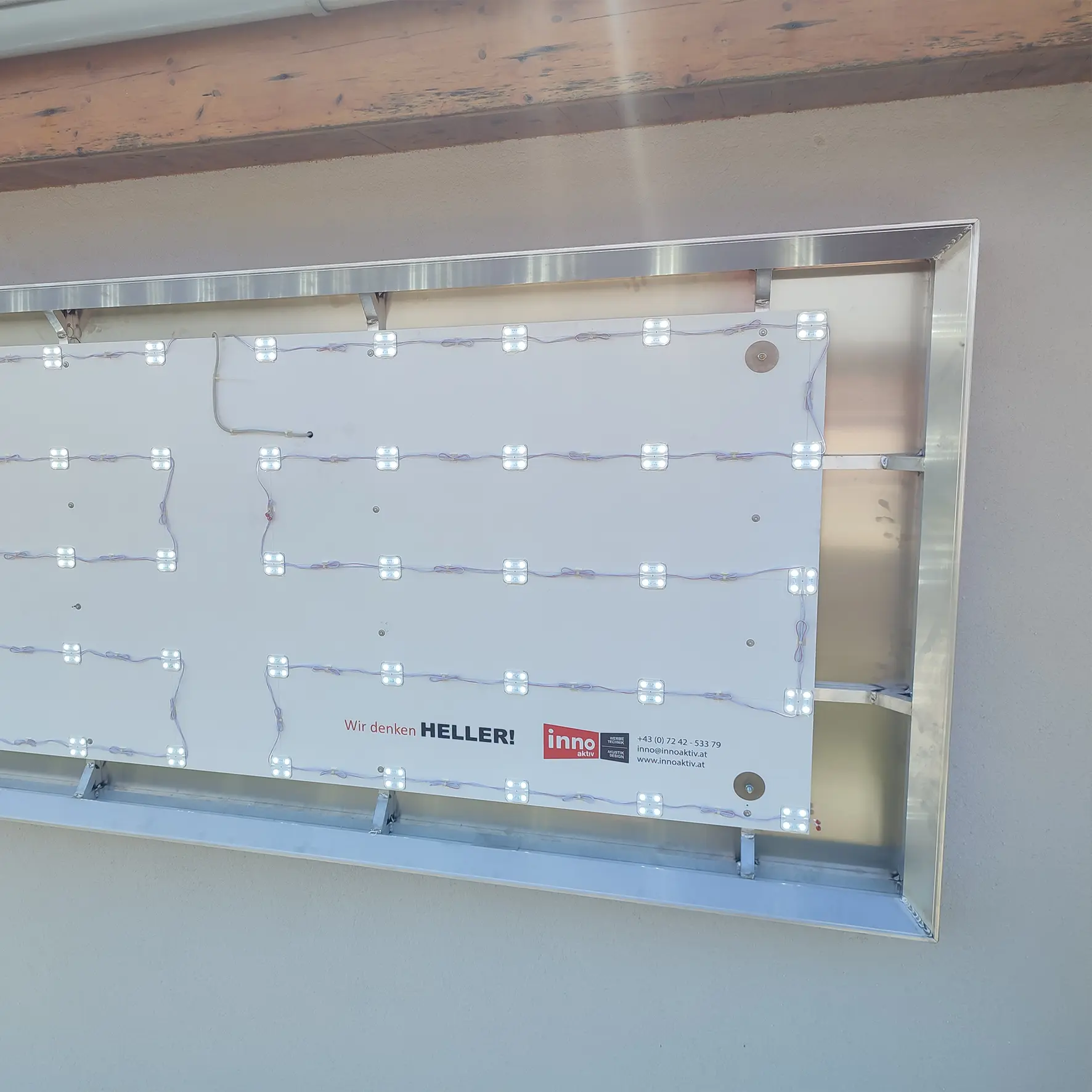 offenes Leuchtschildprofil an Fassade