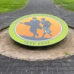 Leuchtscheibe mit Logo vor dem Eingang